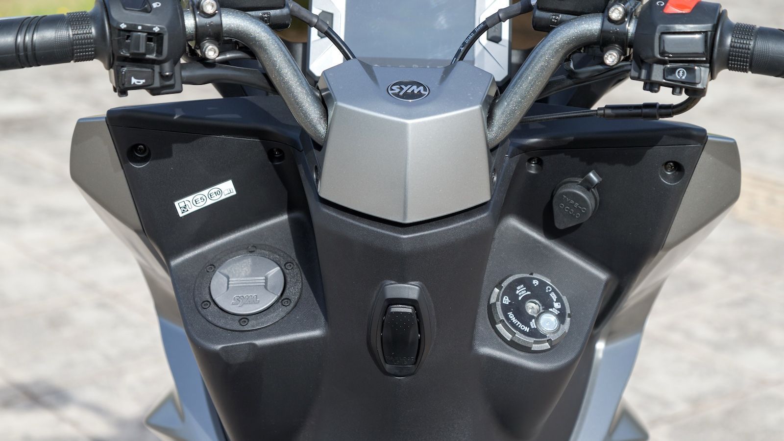 Στην ποδιά βρίσκουμε γάντζο για τσάντες, εξωτερική τάπα ρεζερβουάρ και διπλές θύρες USB (Type-A και Type-C) με δυνατότητα ταυτόχρονης, ταχείας φόρτιση